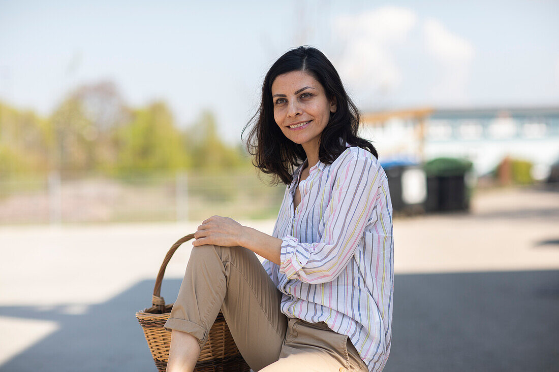 Germany, Freiburg, Smiling woman holding basket