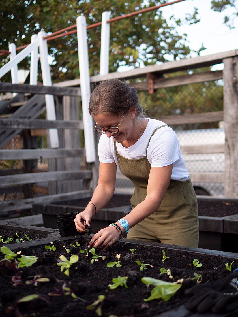 Australien, Melbourne, Lächelnde Frau bei der Arbeit im Gemeinschaftsgarten