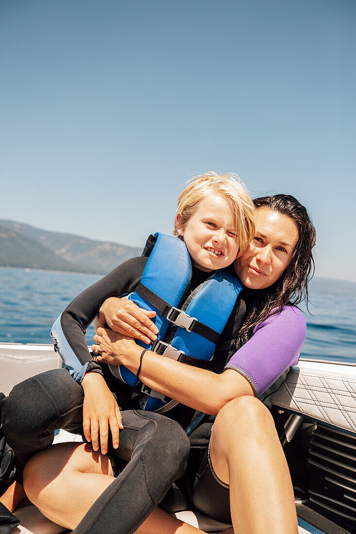 Portrait of mother and son (12-13) on boat