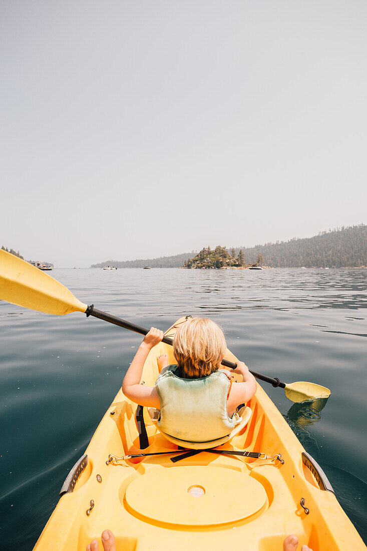 Boy (8-9) rowing in kayak