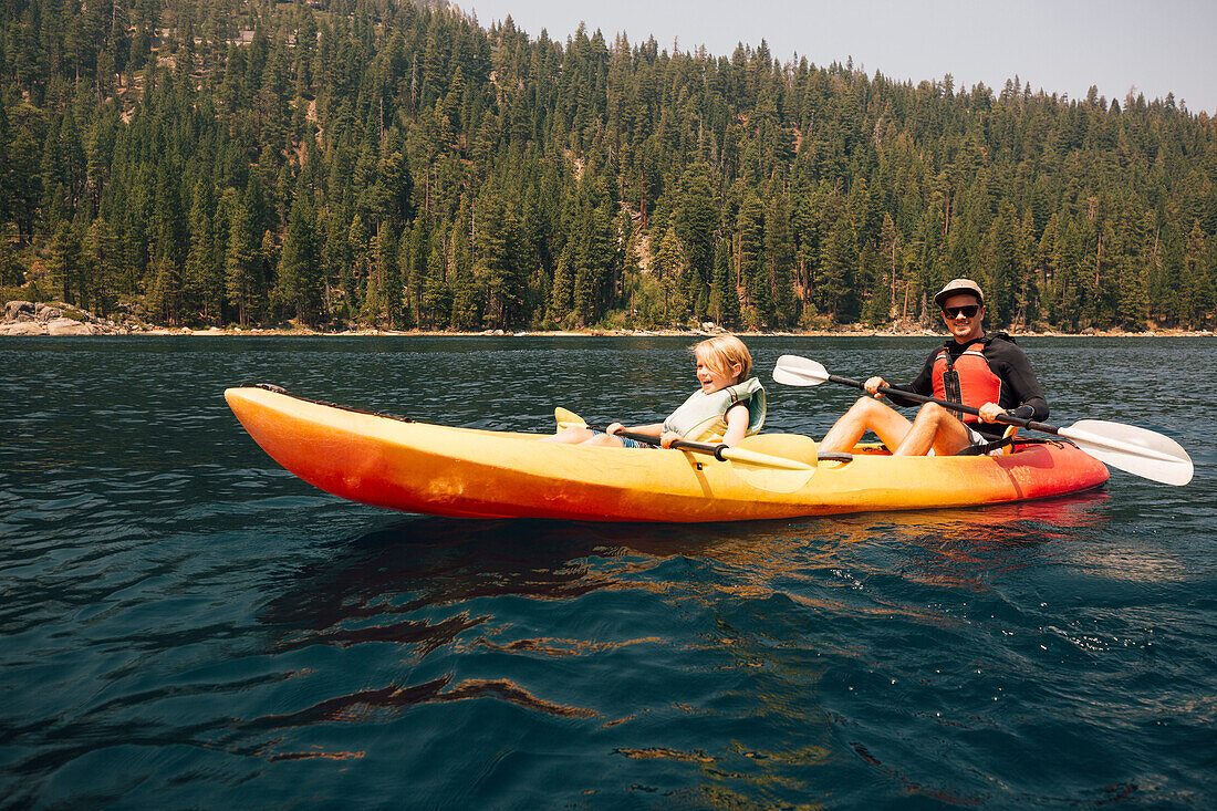 Father with son (7-8) in kayak at lake