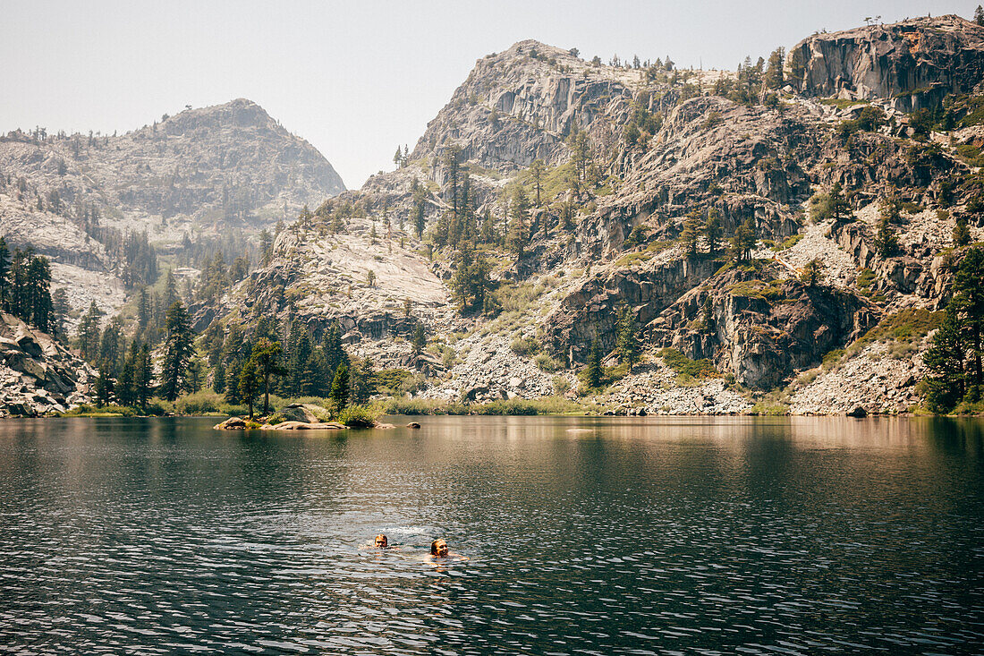 Mother with son (8-9) swimming in lake