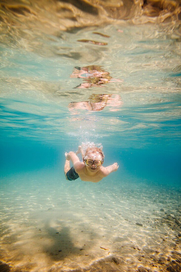 Junge (8-9) schwimmt unter Wasser