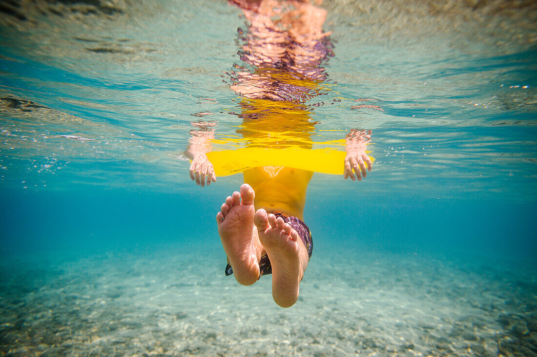 Junge (12-13) schwimmt unter Wasser