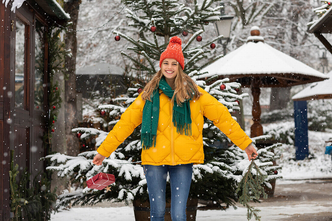 Porträt einer lächelnden jungen Frau, die im Winter im Freien steht