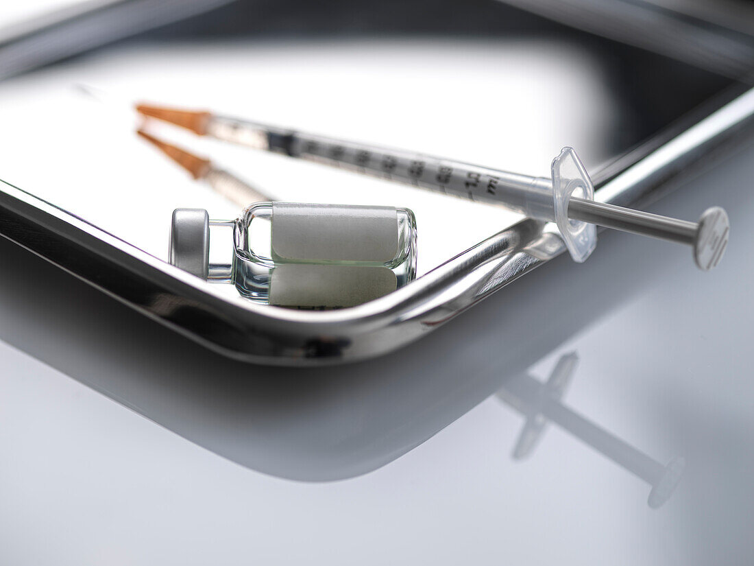 Syringe and vial on metal tray