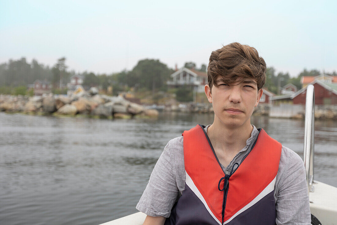 Portrait of boy (15-16) sitting in boat