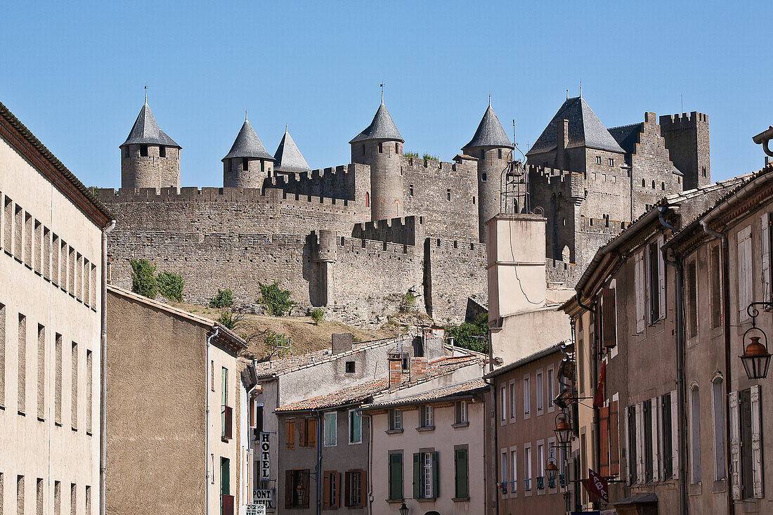 Castle And Ramparts Of The Double-Walled Castle With Modern Residential Buildings In The Foreground; Carcassonne, Languedoc-Rousillion, France