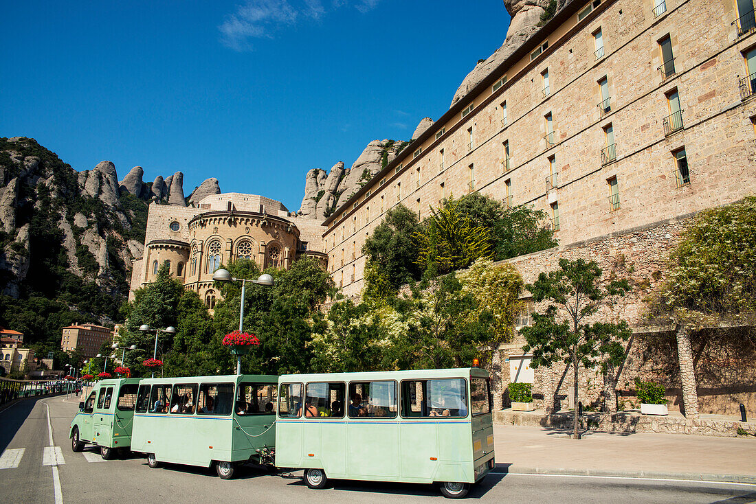 Ein Zug auf der Straße, der Touristen um die Benediktinerabtei herumführt; Montserrat, Katalonien, Spanien