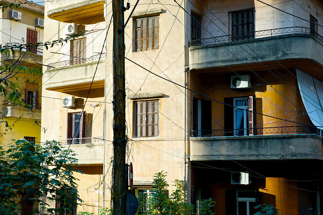 Wohngebäude mit elektrischen Leitungen, die an einem Mast befestigt sind; Beirut, Libanon