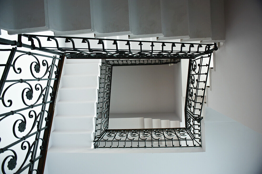 High Angle View Of A Staircase With An Ornate Black Railing; Milan, Italy