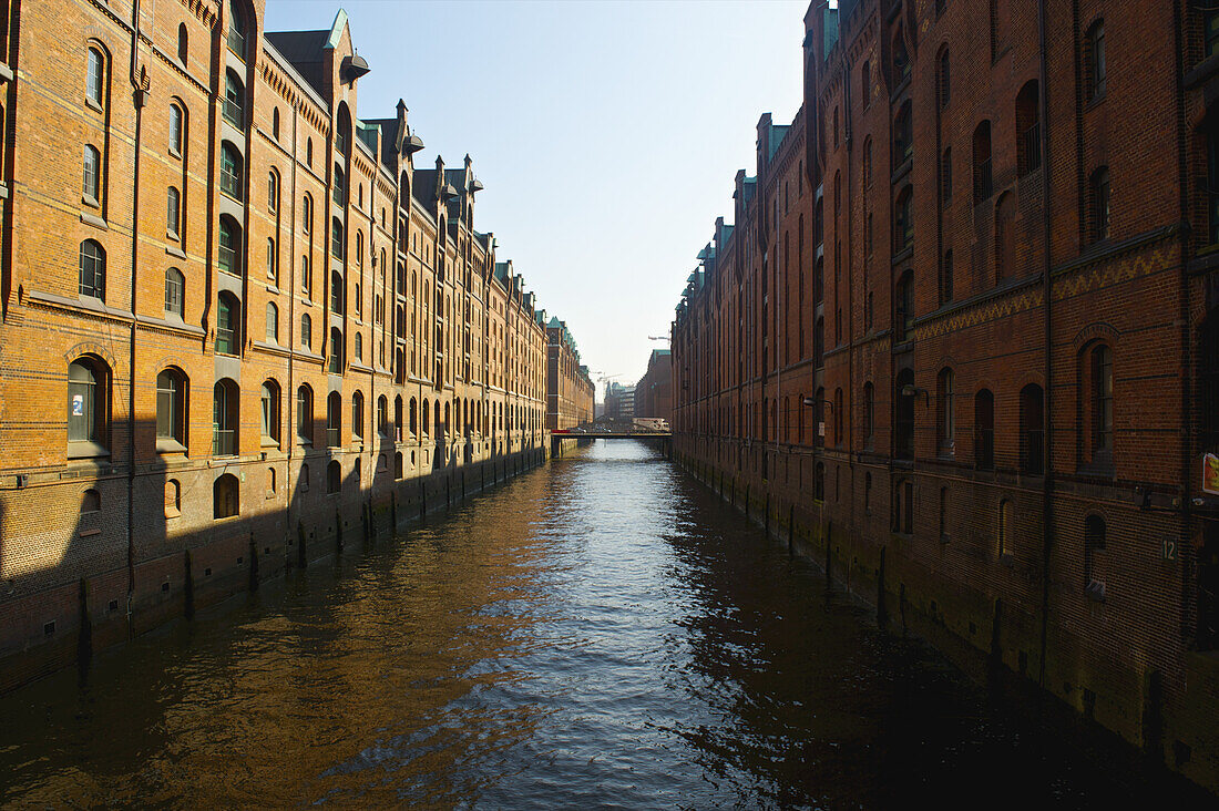 Brown Brick Buildings Along A Canal Under A Blue Sky; Hamburg, Germany