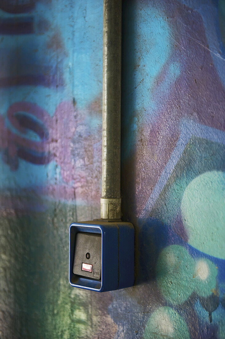 A Card Reader Along A Wall Painted With A Colourful Mural; Hamburg, Germany