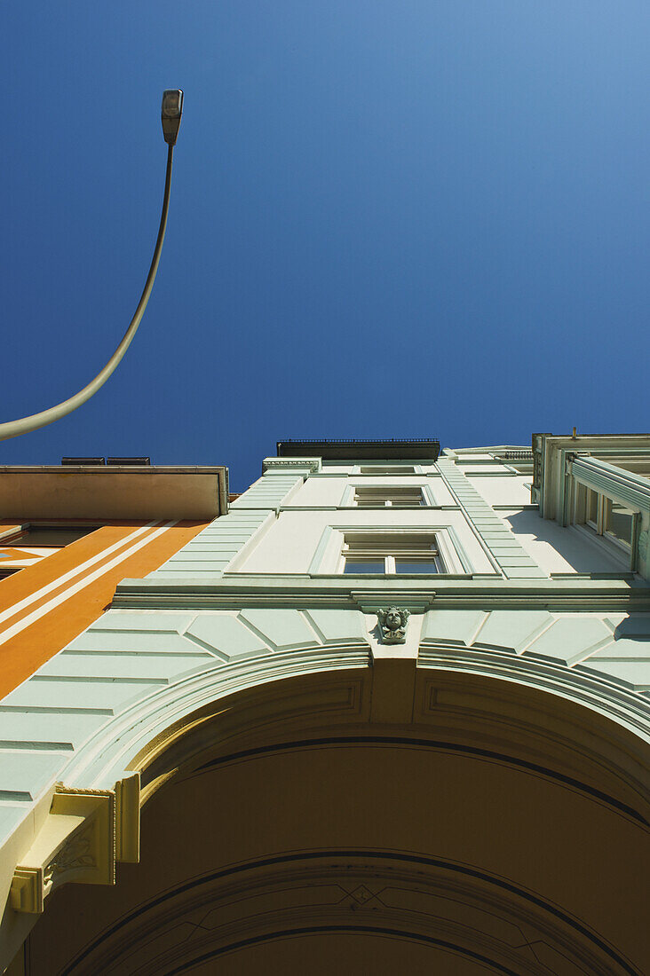 Low Angle View Of The Facade Of A Building With An Archway And Street Light Against A Blue Sky; Hamburg, Germany