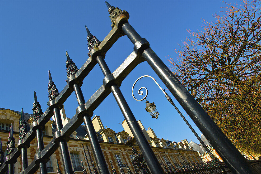 An Ornate Metal Railing By A Building And Blue Sky, Marais District; Paris, France