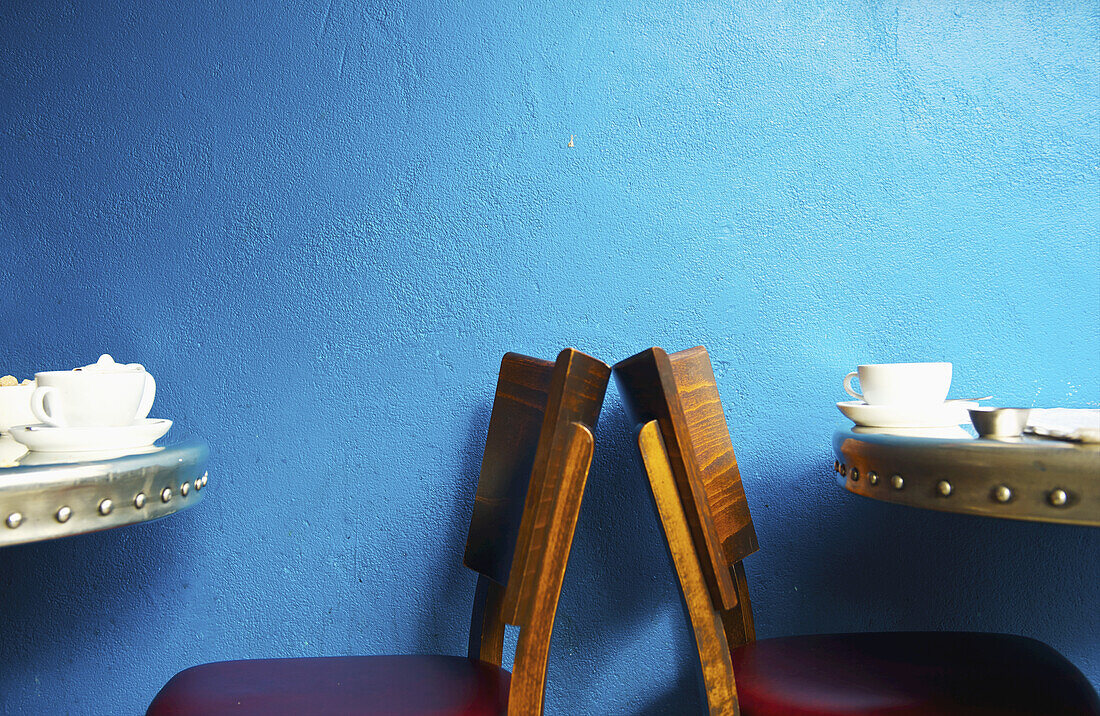 Tische und Holzstühle in einem Café; London, England.