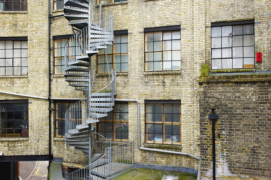 Eine gewundene Treppe an der Außenseite eines Wohngebäudes aus Backstein in Shoreditch; London, England.