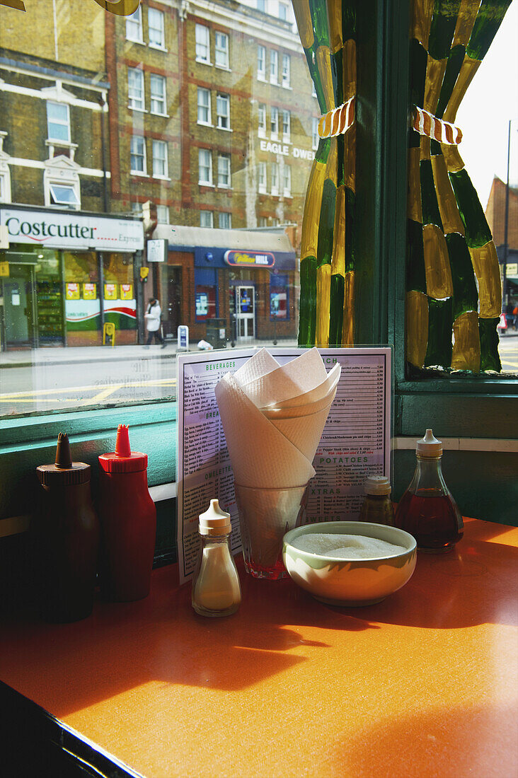 Ein gedeckter Restauranttisch mit Gewürzen und einer Speisekarte, Shoreditch; London, England