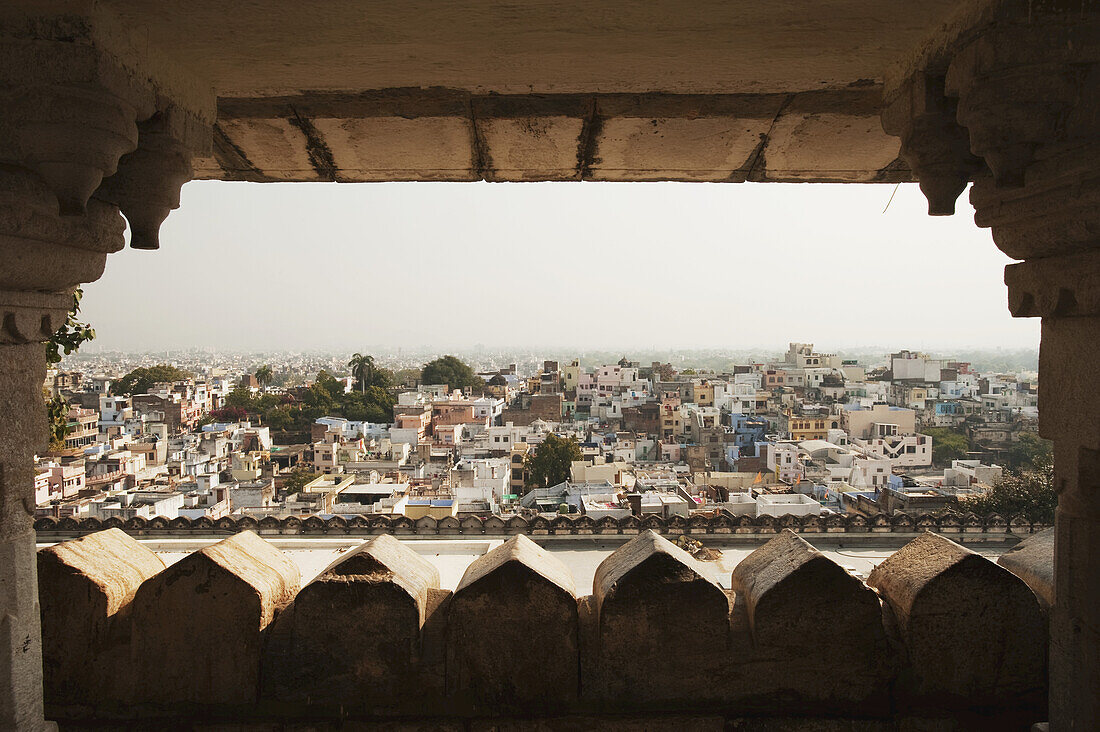 Blick auf eine Stadt durch ein Fenster mit einem dunstigen Himmel; Udaipur, Indien