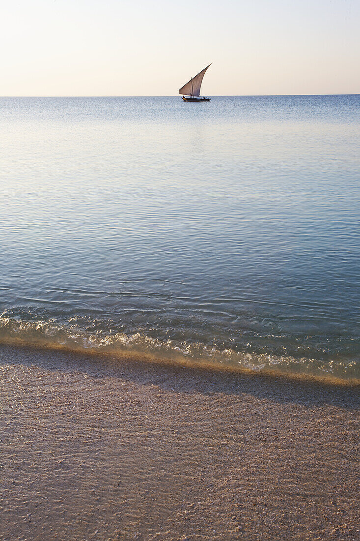 Ein Segelboot in der Ferne auf dem ruhigen Wasser des Indischen Ozeans; Vamizi-Insel, Mosambik