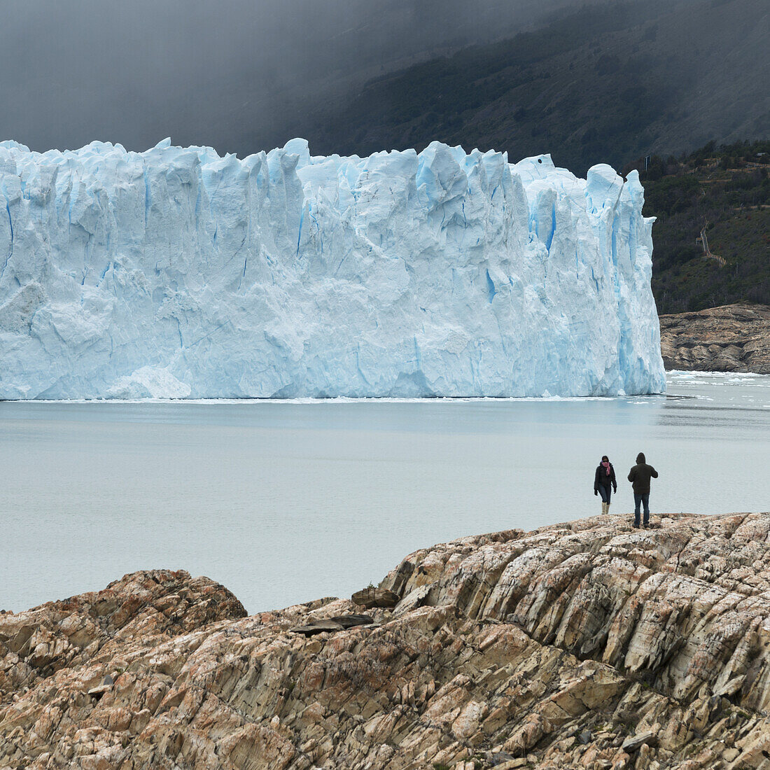 Tourists On The Shore Of Lake Argentino With A View Of Moreno Glacier, Los Glaciares National Park; Santa Cruz Province, Argentina