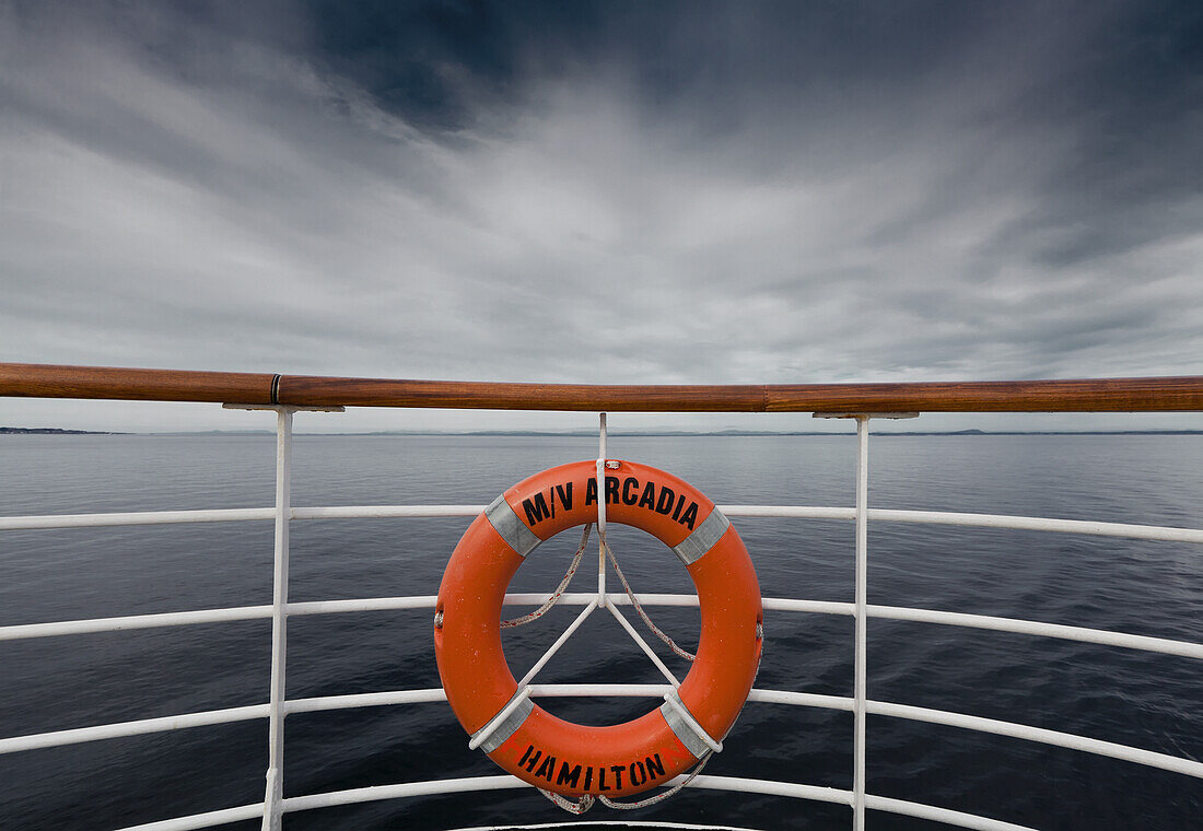 Ein Rettungsring, der an der Reling eines Bootes hängt; Norwegen