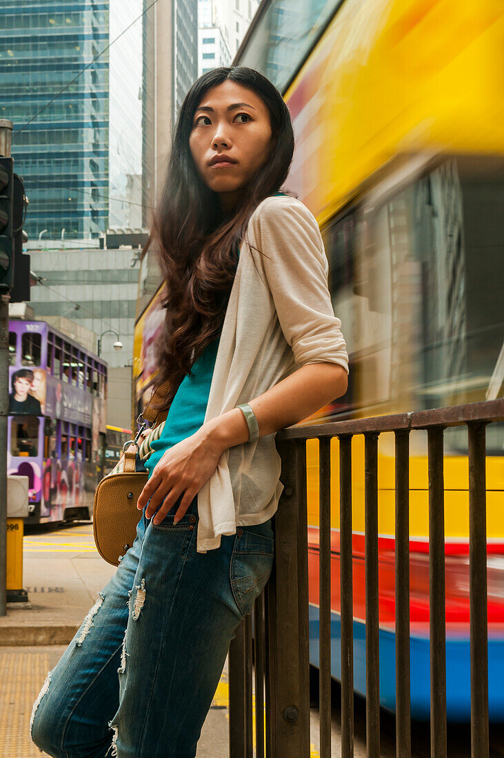 Chinesische junge Frau in einem belebten Stadtzentrum; Hongkong, China.