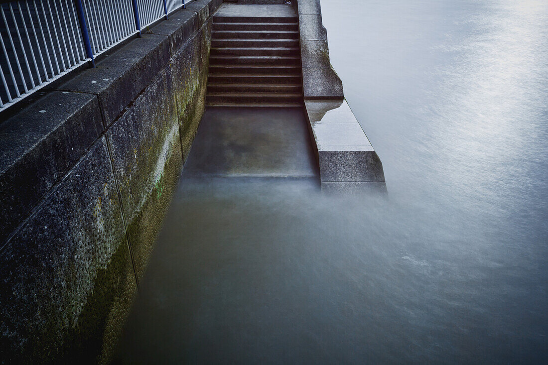 Stufen von der Southbank Promenade hinunter zur Themse; London, England.