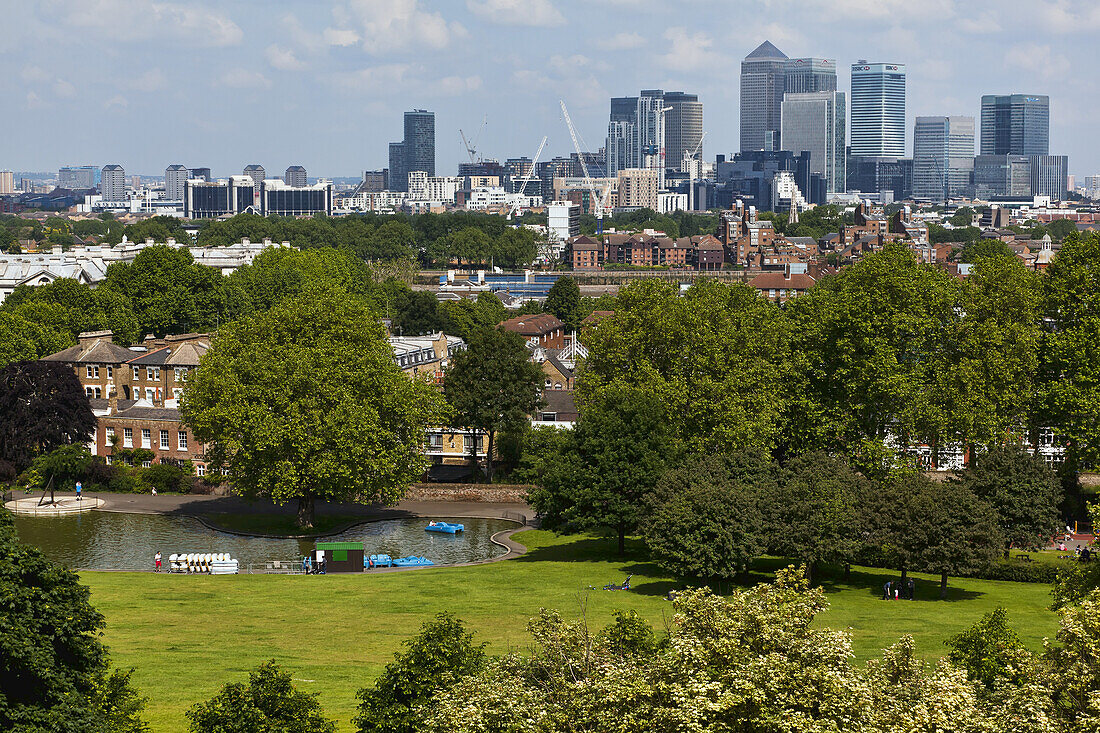 Blick auf Wolkenkratzer in der City of London mit einem Park im Vordergrund; London, England.