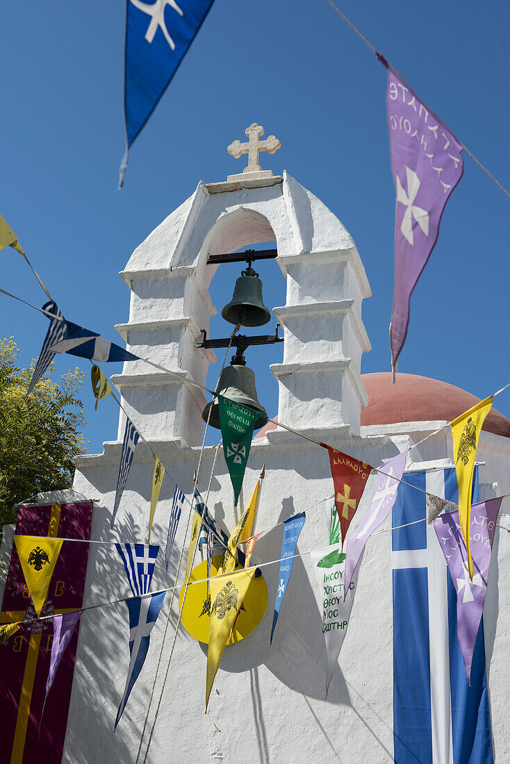 Flags Hanging Around An Old White Washed Church; Mykonos Town, Mykonos, Cyclades, Greek Islands, Greece