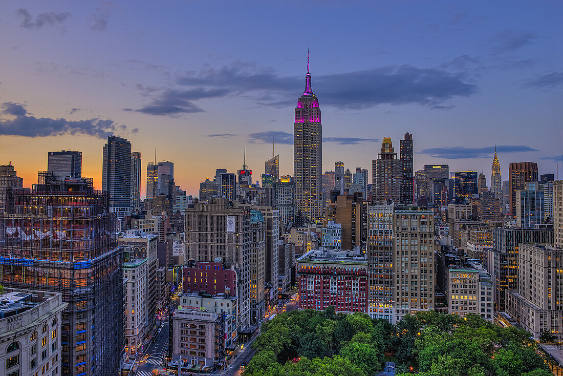 Empire State Building bei Sonnenuntergang mit Fahnen zu Ehren des Military Order Of The Purple Heart; New York City, New York, Vereinigte Staaten von Amerika