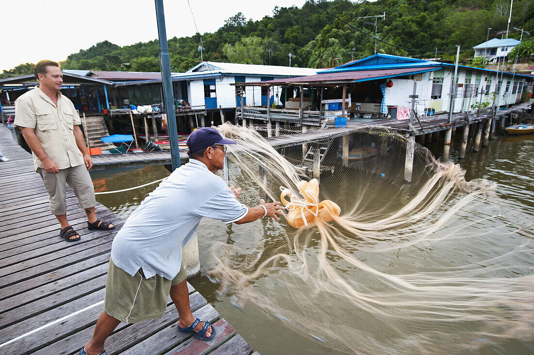 Tourist lernt Netzfischen in einem kleinen Dorf; Brunei