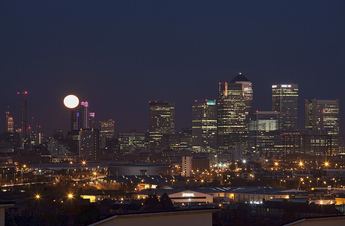 Untergehender Vollmond über Canary Wharf; London, England