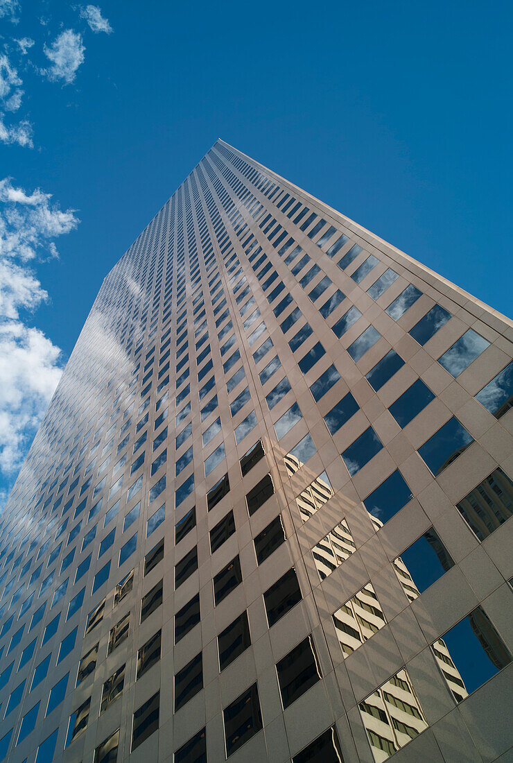 Skyscraper Reflecting Another Building In It's Windows With Blue Sky And Cloud; Denver, Colorado, United States Of America