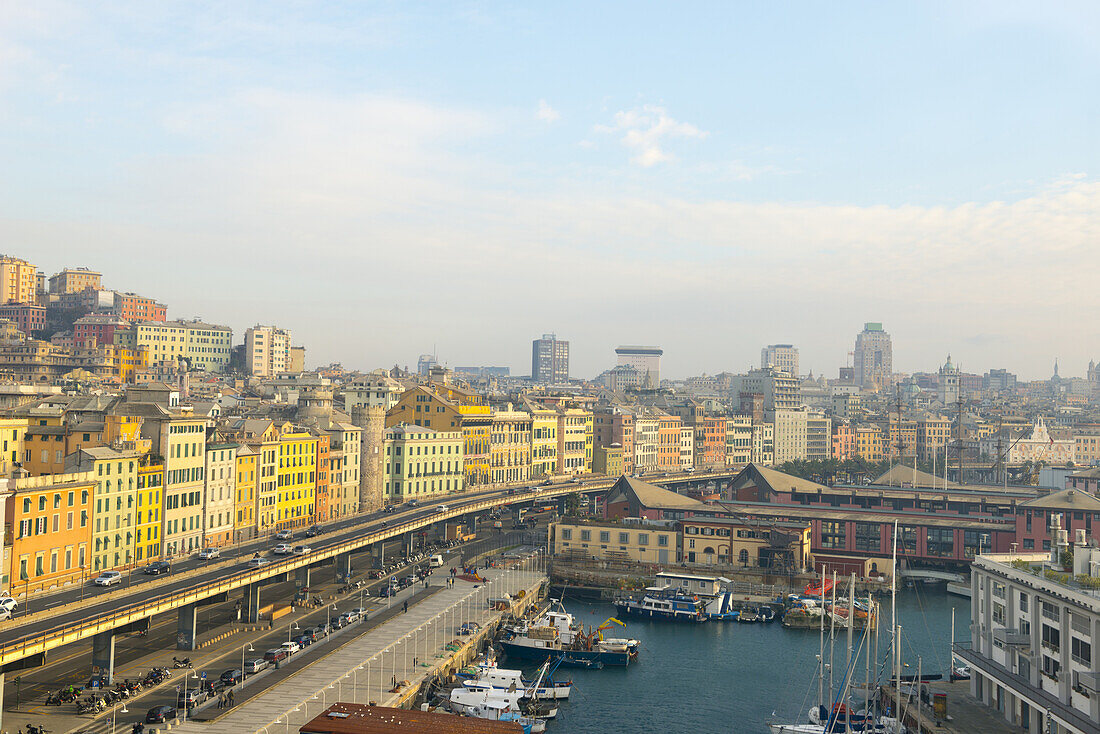 Bunte Gebäude entlang der Uferpromenade und Boote im Hafen; Genua, Ligurien, Italien