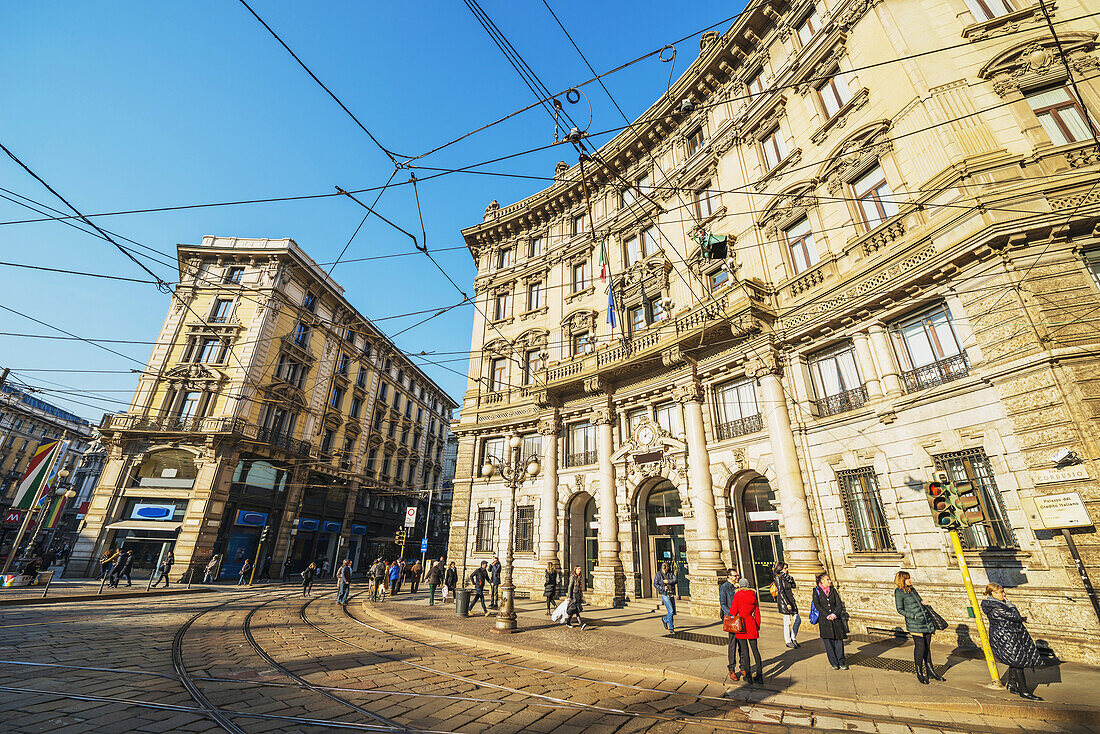 Pedestrians Wait For The Tram; Milan, Lombardy, Italy