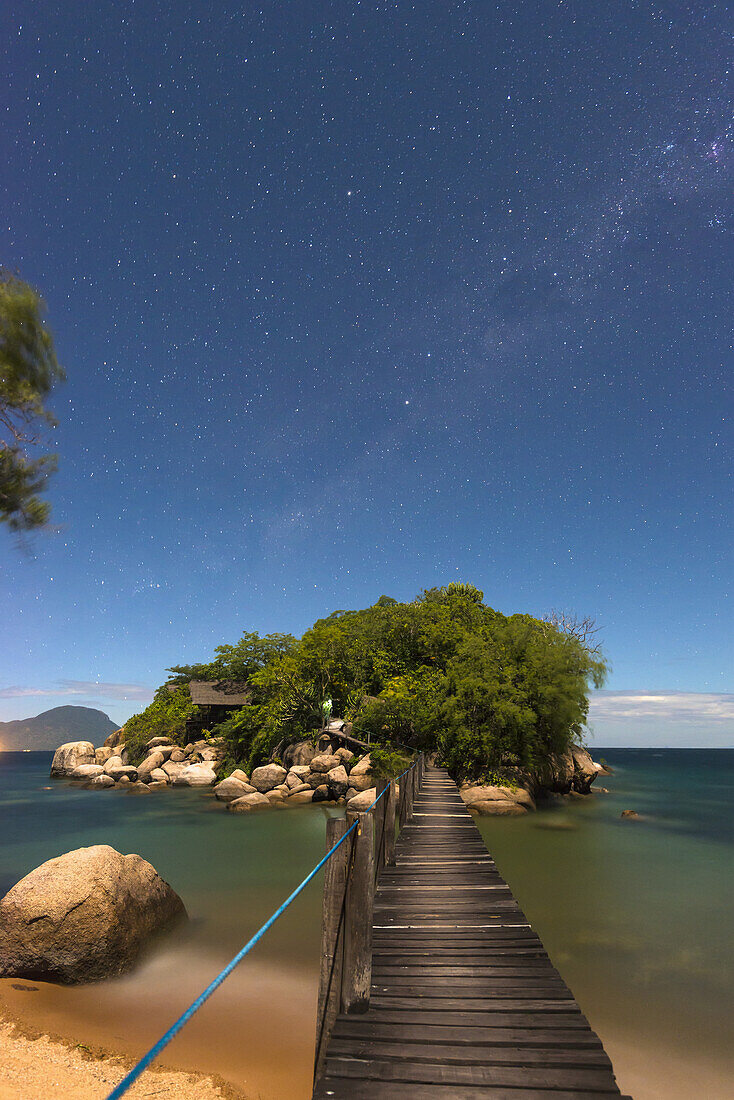 Kleine Brücke von der Mumbo-Insel zur kleinen Insel für Touristenunterkünfte unter dem Sternenhimmel, Malawi-See; Malawi.