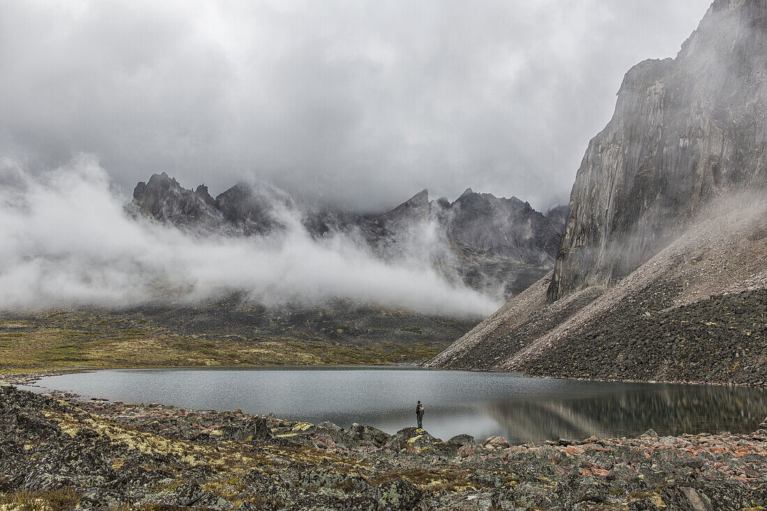 Person Standing On The Misty Shores Of Talus Lake, Which Lies Deep Within The Yukon's Tombstone Territorial Park; Yukon, Canada