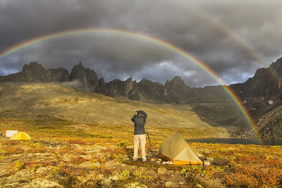 Fotograf beim Fotografieren des späten Nachmittagslichts, das auf die Berge im Tombstone Territorial Park des nördlichen Yukon trifft; Yukon, Kanada