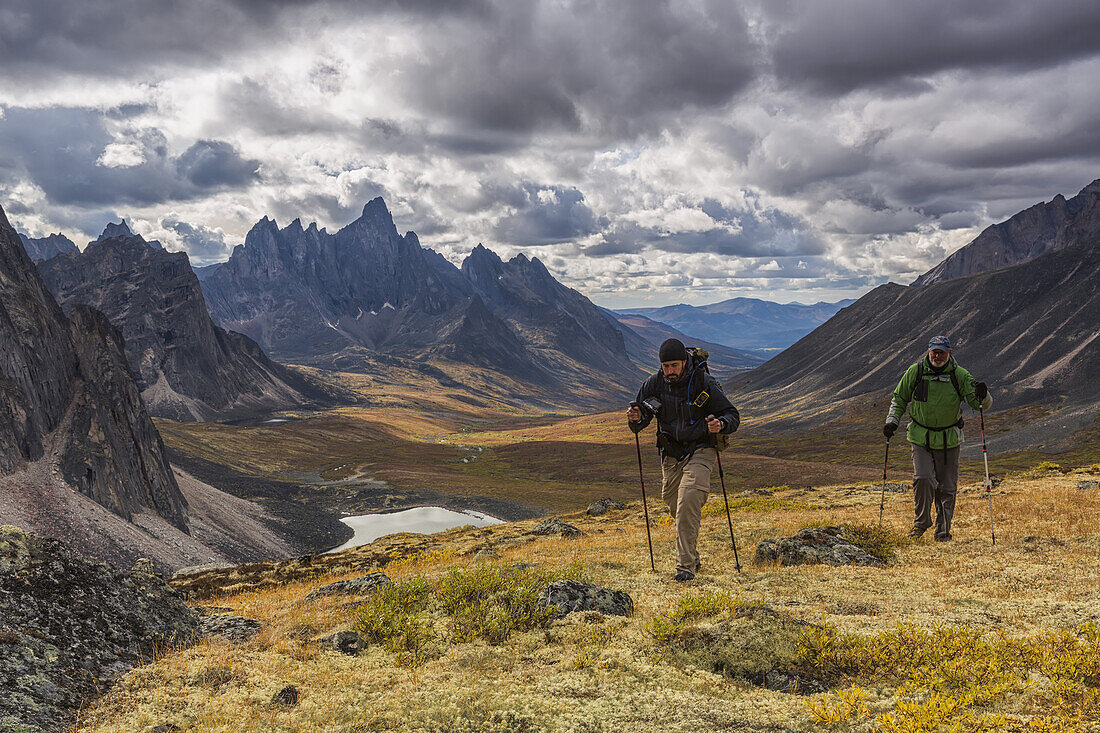 Wanderer auf einem Bergrücken im Tombstone Territorial Park im Herbst, mit dem Tombstone Valley und dem Tombstone Mountain in der Ferne; Yukon, Kanada.