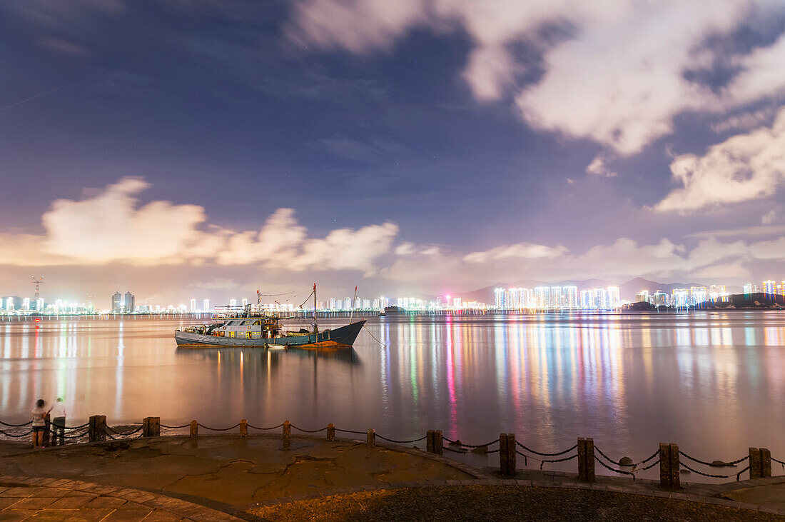 Landschaft aus der Bucht von Xiamen, ein altes Boot, das wegen der Ebbe in der Mitte des Meeres festsitzt; Provinz Fujian, China