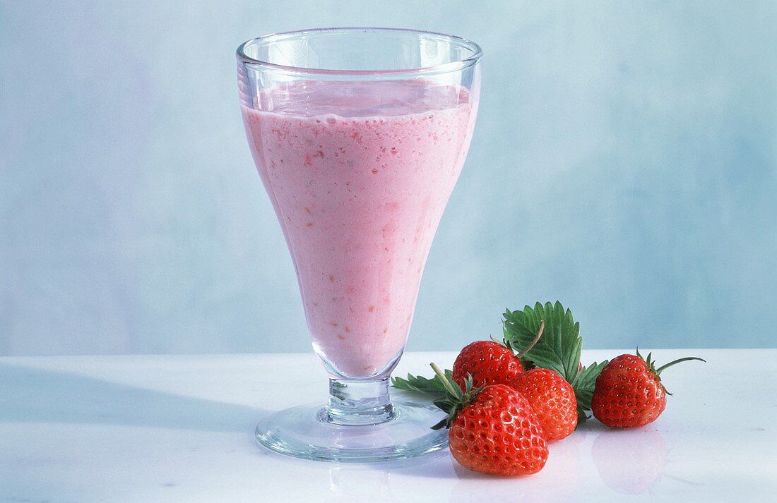 Erdbeermilch im Glas & frische Erdbeeren daneben