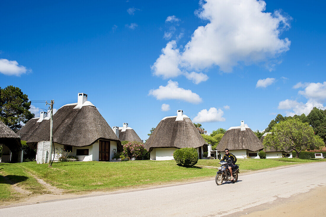 Cycling Down A Road With Traditional Houses; La Pedrera, Uruguay