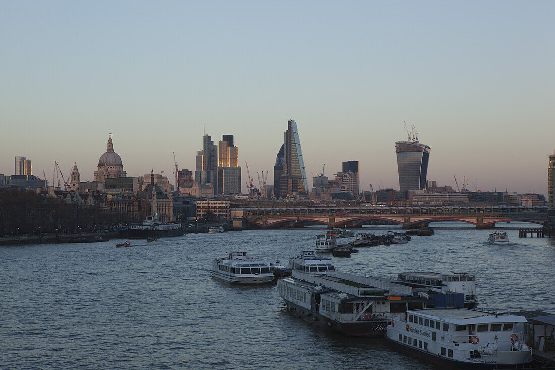 Abenddämmerung an der Themse im Zentrum Londons, mit Blick auf die St. Paul's Cathedral und viele neue Wolkenkratzer im Finanzdistrikt der City of London; London, England.