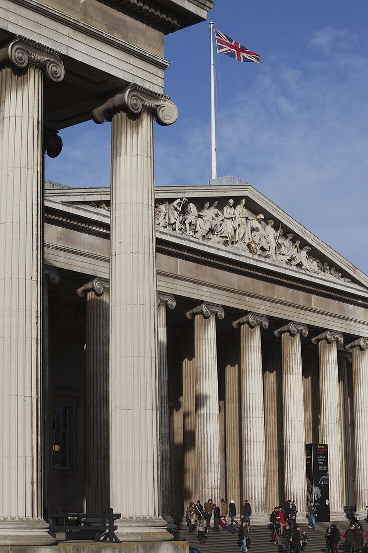 Die neoklassizistische Fassade des Britischen Museums mit der Flagge des Union Jack; London, England.