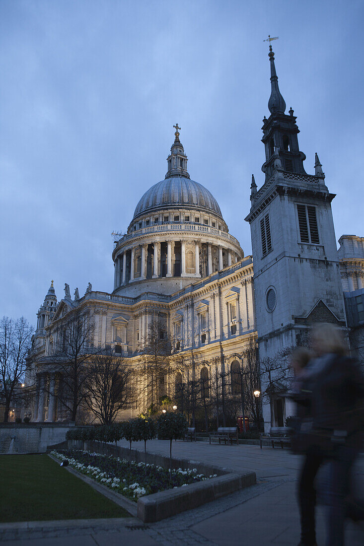 Two People Walking Past St. Paul's Cathedral At Dusk; London, England