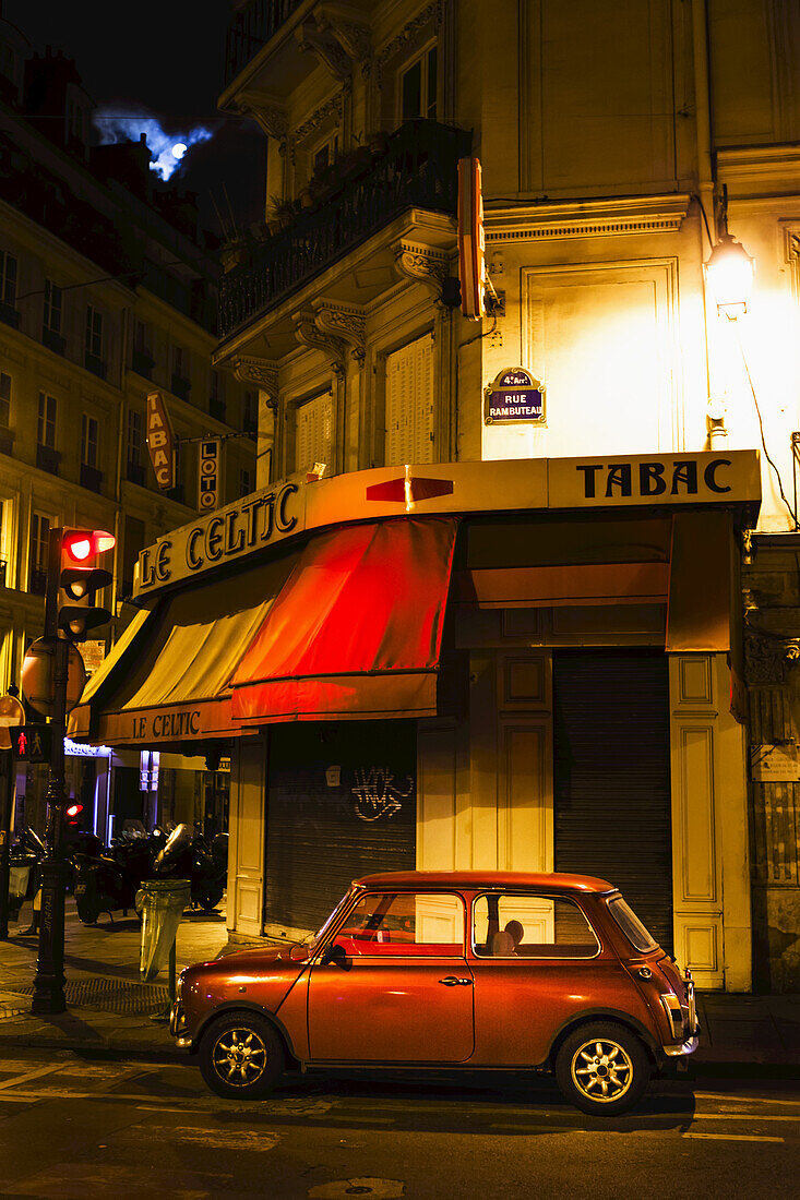 City Street With A Red Hatch Back Car And Full Moon; Paris, France