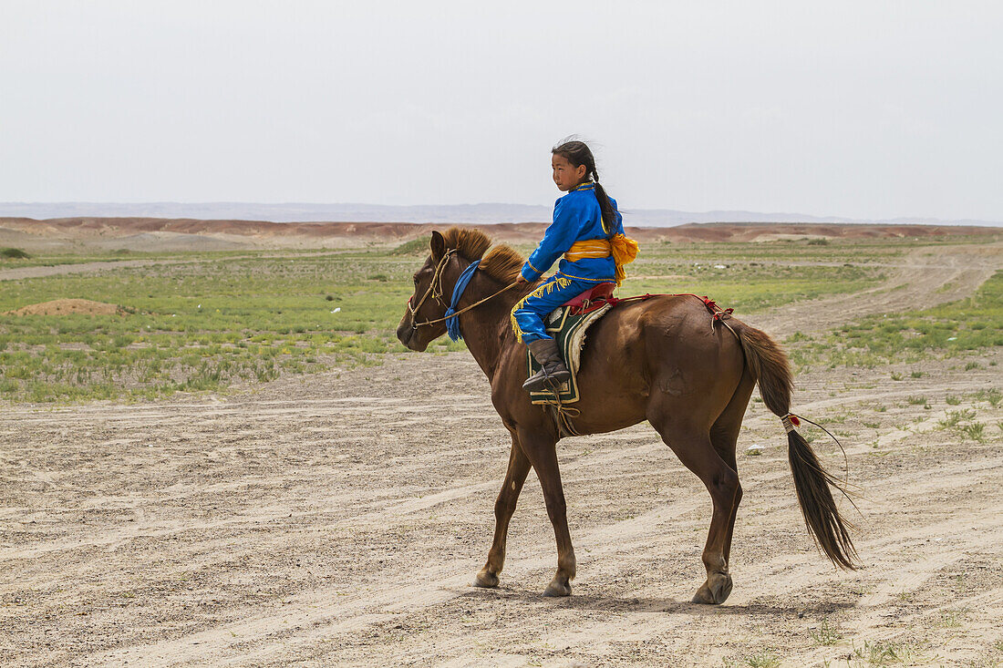 Mädchen reitet auf einem Pferd beim Naadam-Festival in Mandal Ovoo, vEmnv?govi-Provinz, Mongolei