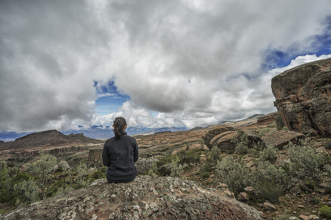 Eine Frau sitzt auf einem Felsen und blickt auf die schöne Landschaft des Toro Toro Nationalparks; Bolivien