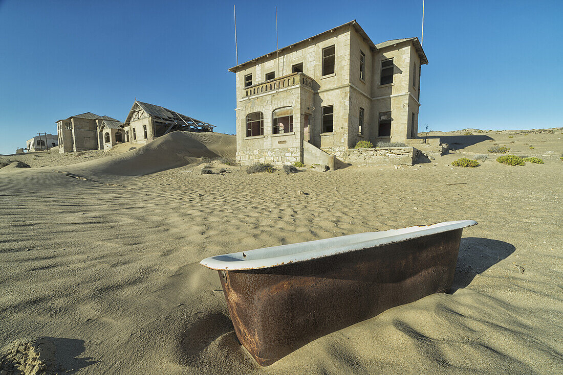 Verlassene Häuser mit einer im Sand liegenden alten Badewanne; Kolmanskop, Namibia